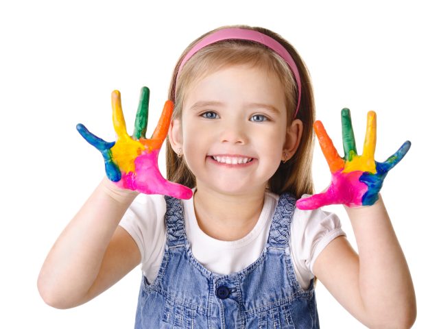 Beautiful smiling little girl with hands in the paint isolated on white